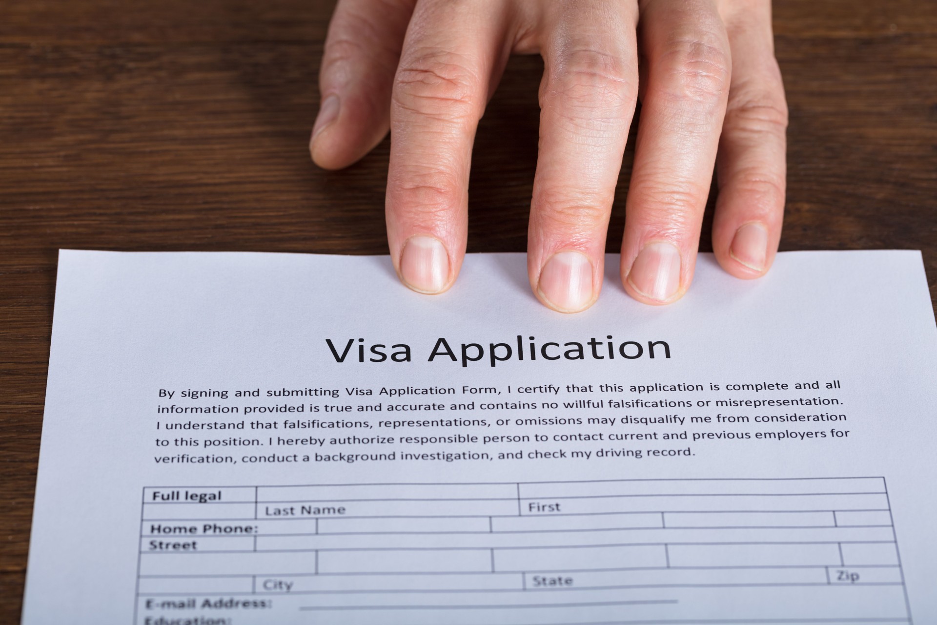 Person Hand On Visa Application Form